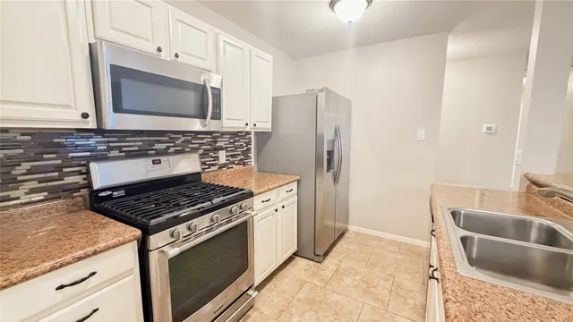 a kitchen with stainless steel appliances granite countertop a stove a sink and a microwave