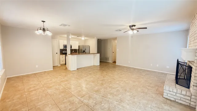 a view of a kitchen with a stove cabinets a ceiling fan and wooden floor