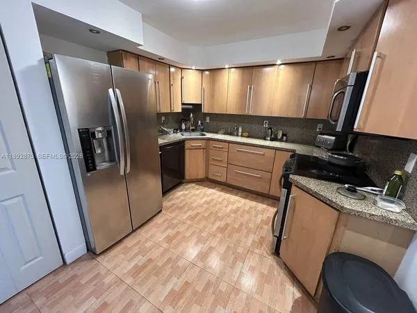 a kitchen with a refrigerator sink and cabinets