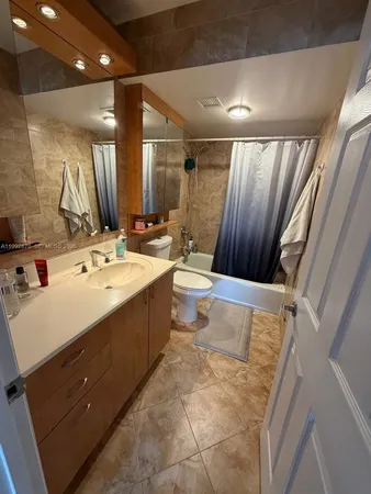 a bathroom with a double vanity sink a mirror and a bathtub