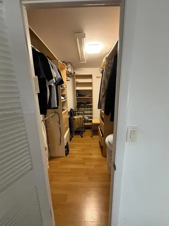 a view of walk in closet with clothes and shoes