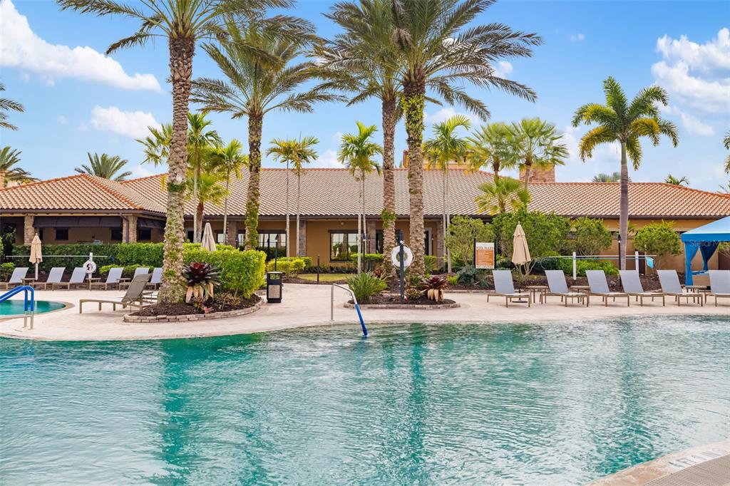 13725 Messina Loop, Unit 104 Bradenton, FL 34211 - Photo 41 of 77 a view of a swimming pool with a table and chairs under an umbrella