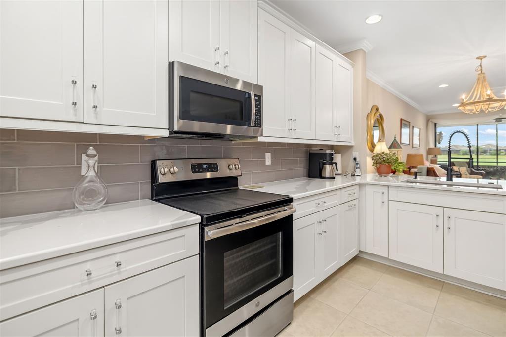 13725 Messina Loop, Unit 104 Bradenton, FL 34211 - Photo 10 of 77 a kitchen with white cabinets and appliances
