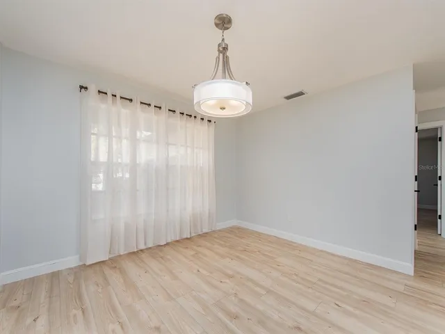 a view of a room with wooden floor and windows
