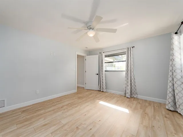 wooden floor in an empty room with a window