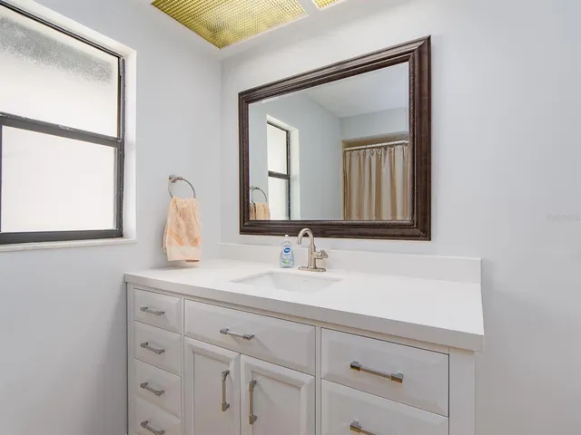 a bathroom with a sink vanity and mirror
