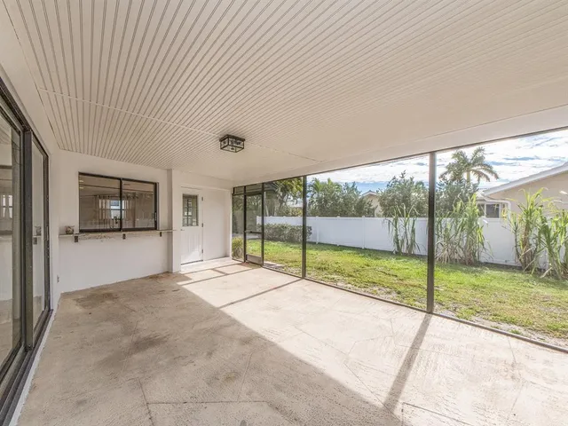 a view of an empty room with a sliding door and garden