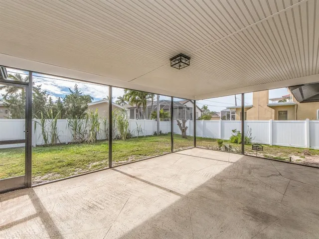 a view of an empty room with wooden floor and windows