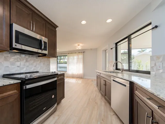 a kitchen with stainless steel appliances a stove sink and microwave