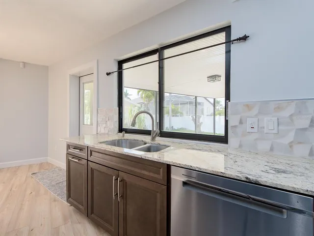 a kitchen with granite countertop a sink and a window