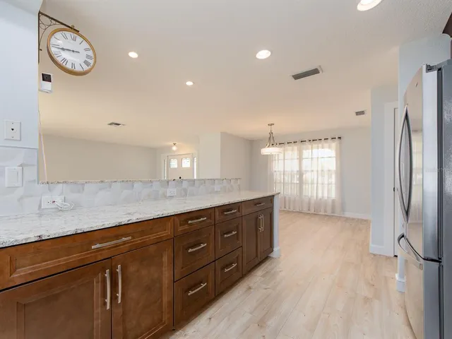 a spacious bathroom with a granite countertop sink a large mirror and a window