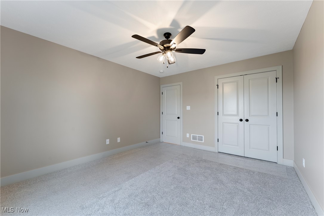 8664 Akron Road Marshallville, OH 44645 - Photo 23 of 29 Unfurnished bedroom featuring a closet, light colored carpet, and ceiling fan