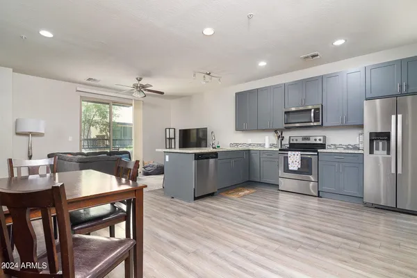 a kitchen with refrigerator cabinets and wooden floor