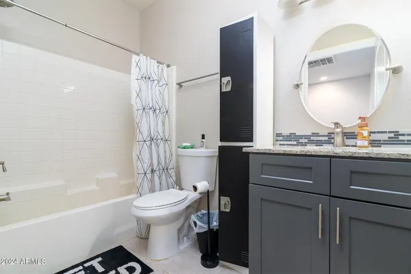 a bathroom with a bathtub sink mirror toilet and shower