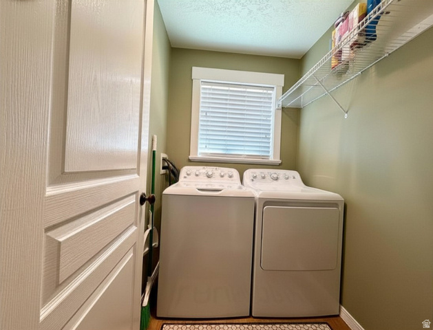 202 375 West Providence, UT 84332 - Photo 27 of 61 Conveniently placed laundry room on main floor next to kitchen featuring a textured ceiling and independent washer and dryer
