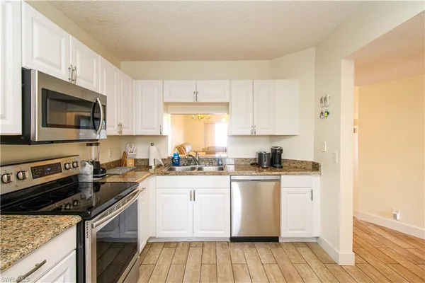 a kitchen with a sink stove top oven and microwave