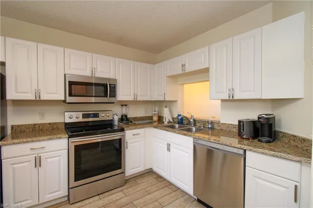 a kitchen with sink a microwave and cabinets