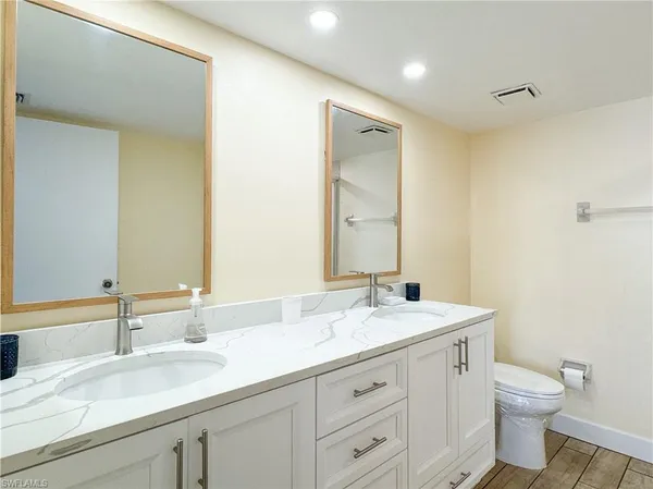 a bathroom with a granite countertop sink a toilet and a mirror