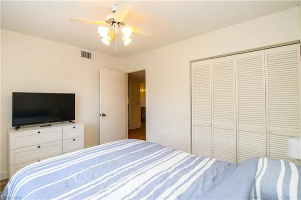 a bedroom with a bed tv and a chandelier