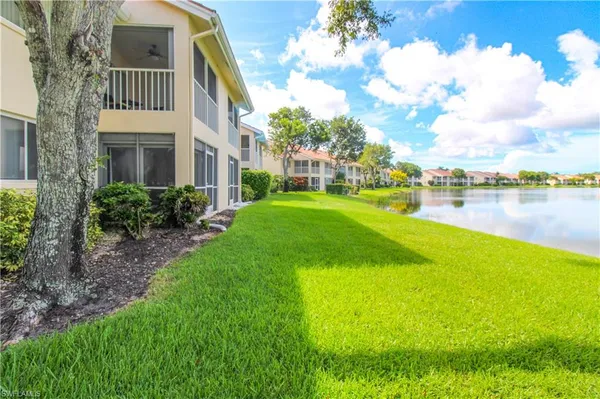 a view of a house with a yard and lake view