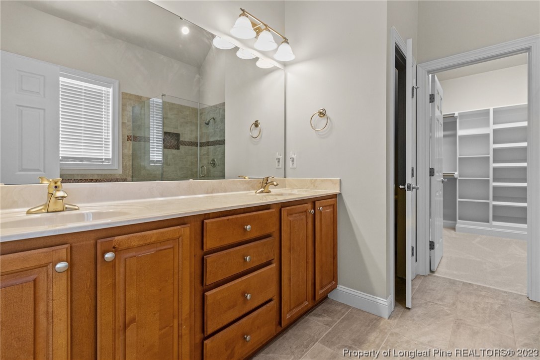 505 Falling Water Road Spring Lake, NC 28390 - Photo 27 of 40 a spacious bathroom with a double vanity sink a large mirror and a shower
