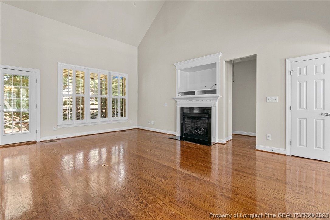 505 Falling Water Road Spring Lake, NC 28390 - Photo 10 of 40 an empty room with wooden floor fireplace and windows
