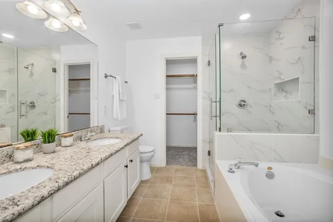 a bathroom with a granite countertop tub sink and shower
