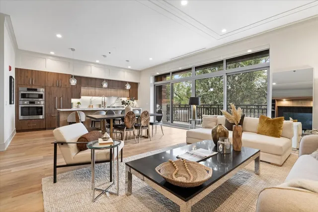 a kitchen with stainless steel appliances kitchen island granite countertop a table chairs and a refrigerator