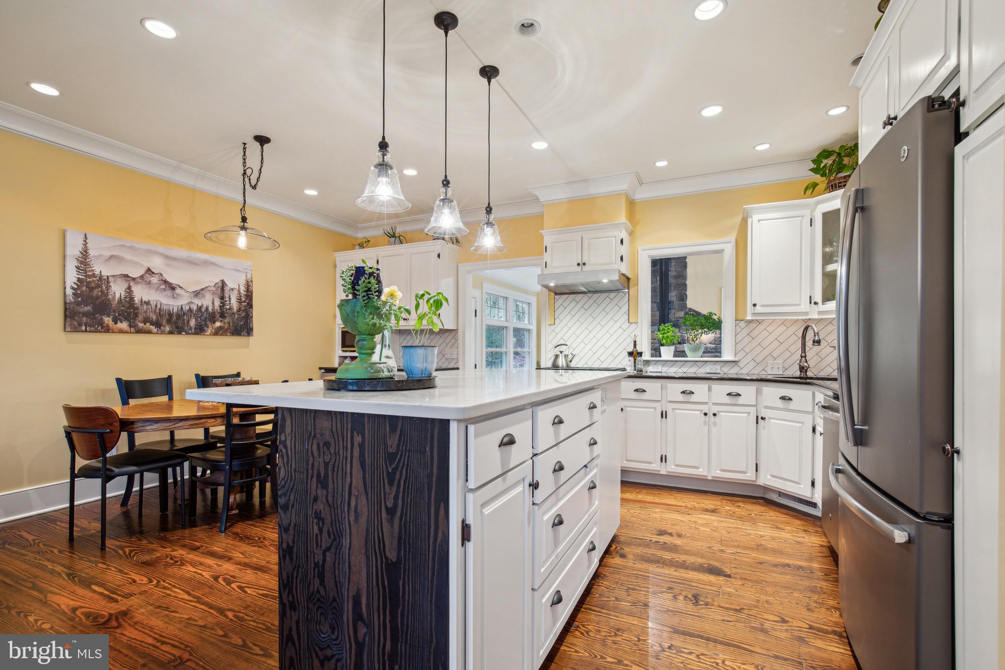 810 Macsherry Drive Arnold, MD 21012 - Photo 3 of 41 a kitchen with stainless steel appliances kitchen island granite countertop a table chairs and a refrigerator