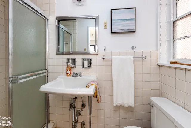 a white bath tub sitting next to a white sink and a mirror