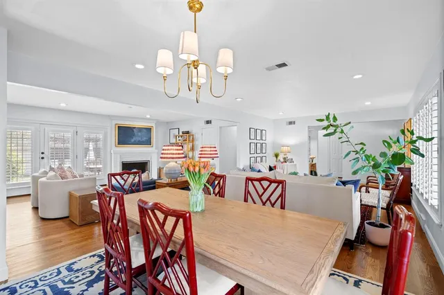 a view of a dining room with furniture a chandelier and wooden floor