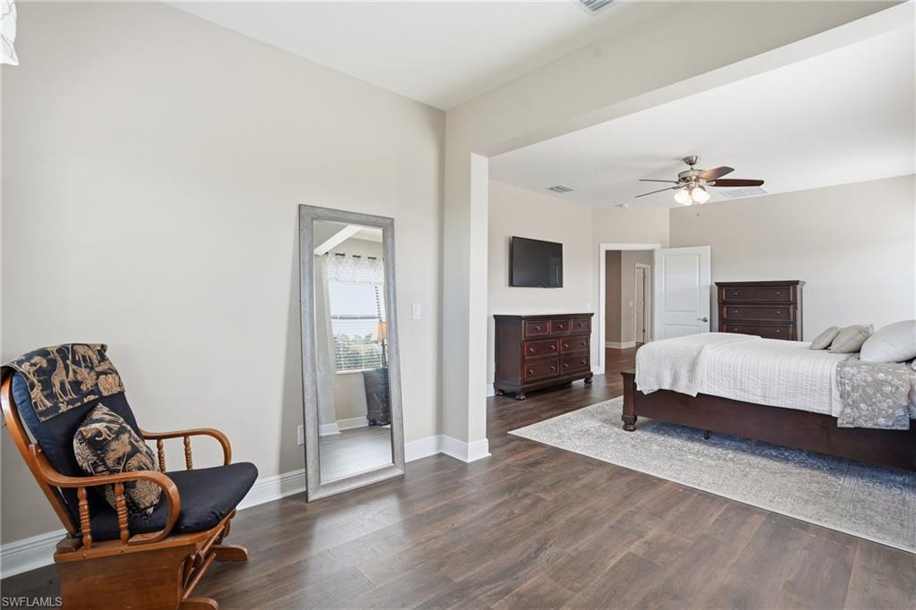 4609 Abaca Circle Naples, FL 34119 - Photo 24 of 49 a spacious bedroom with a bed and a fireplace