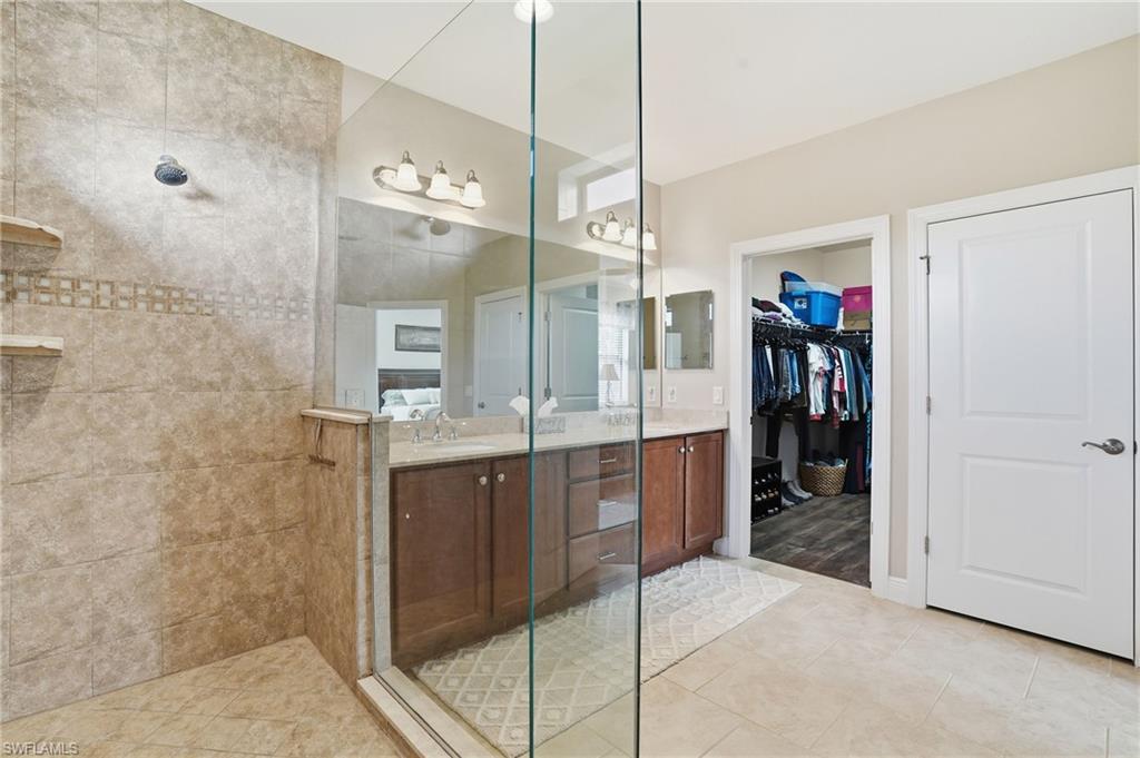 4609 Abaca Circle Naples, FL 34119 - Photo 26 of 49 a bathroom with a granite countertop sink mirror and shower