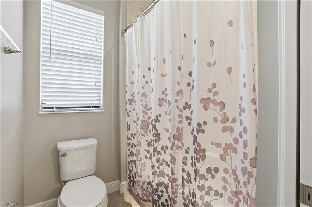 4609 Abaca Circle Naples, FL 34119 - Photo 30 of 49 a white toilet sitting next to a shower curtain