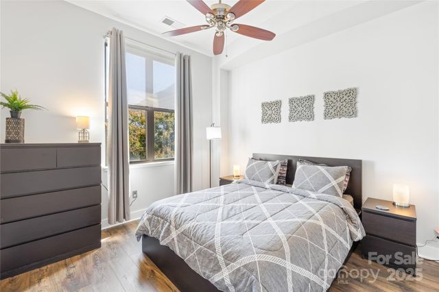 a bedroom with a large bed and a chandelier
