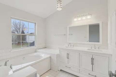 a bathroom with a tub sink and mirror