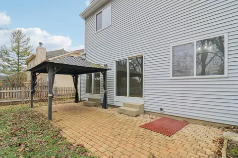 a backyard of a house with barbeque oven table and chairs