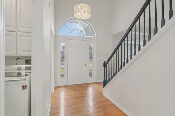 a view of a hallway with wooden floor and staircase