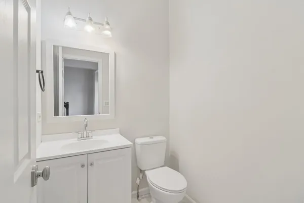 a bathroom with a toilet a sink and mirror