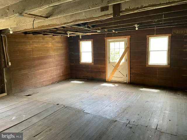 a view of a room with wooden walls and a window