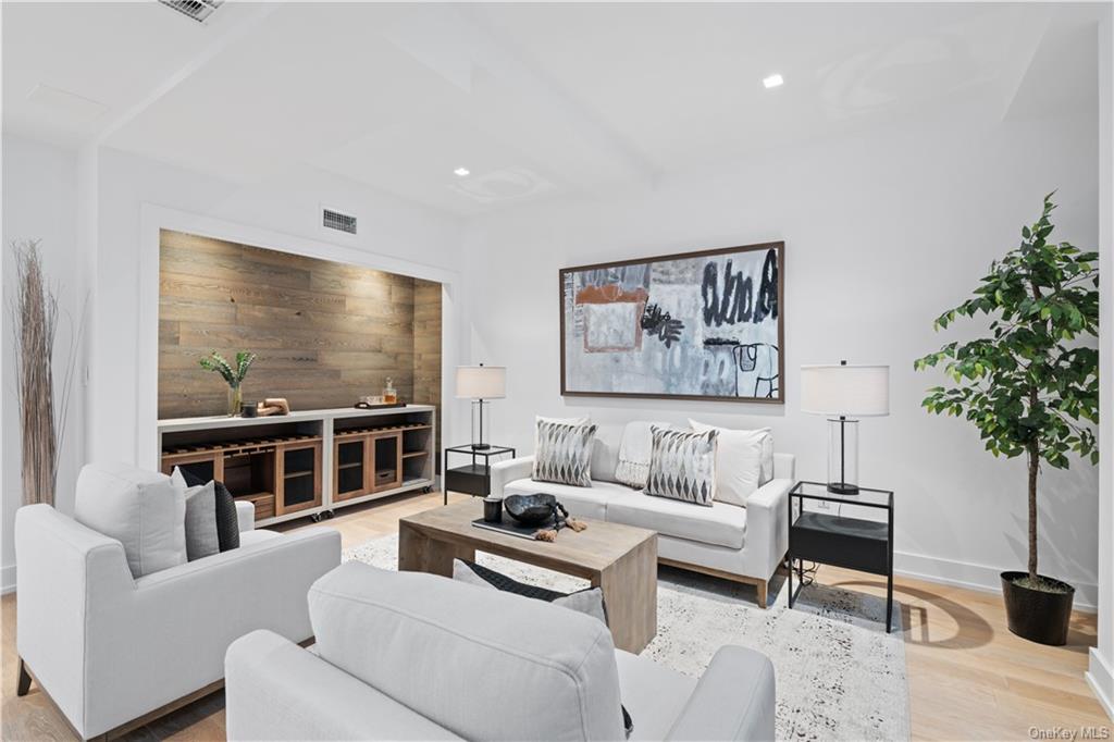 a living room with furniture a chandelier and a flat screen tv