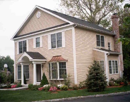 38 Wilton Hunt Road, Unit 19 Wilton, CT 06897 - Photo 1 of 1 a front view of a house with a yard and potted plants