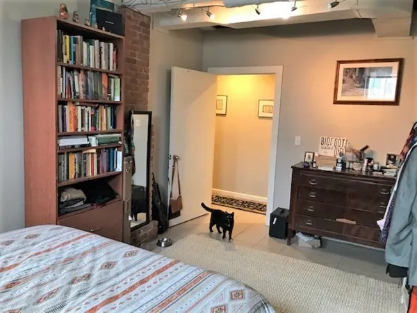 a bedroom with a bed and a book shelf