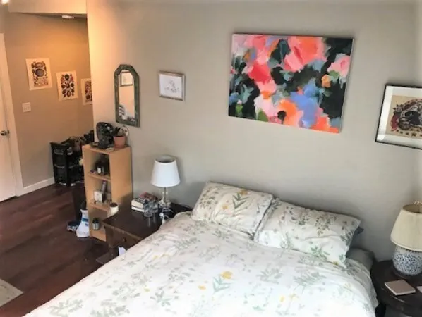 a bedroom with a bed and wooden floor