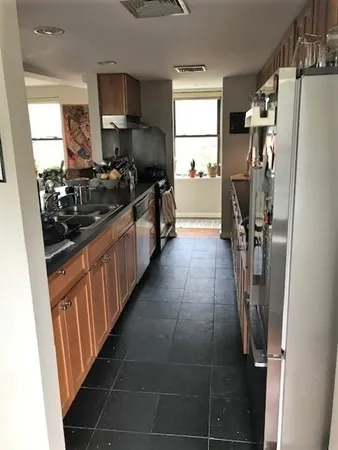 a kitchen with stainless steel appliances a refrigerator a sink a stove and wooden floor