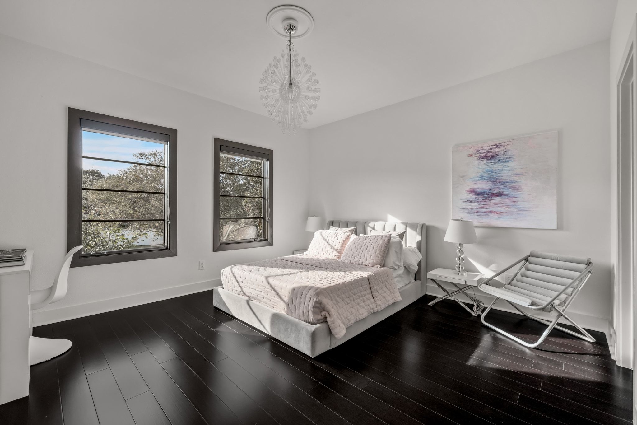 4720 Rockcliff Road, Unit 1 Austin, TX 78746 - Photo 30 of 39 Rich dark hardwood flooring grounds this inviting primary bedroom, illuminated by ample natural light.