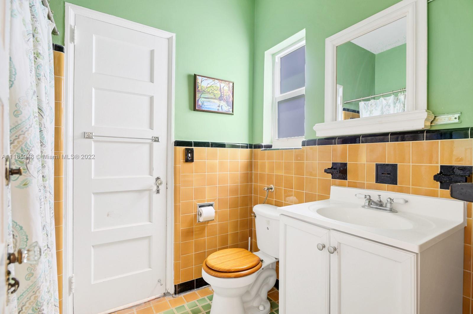 5429 Alton Road Miami Beach, FL 33140 - Photo 12 of 20 a bathroom with a sink a toilet and a mirror