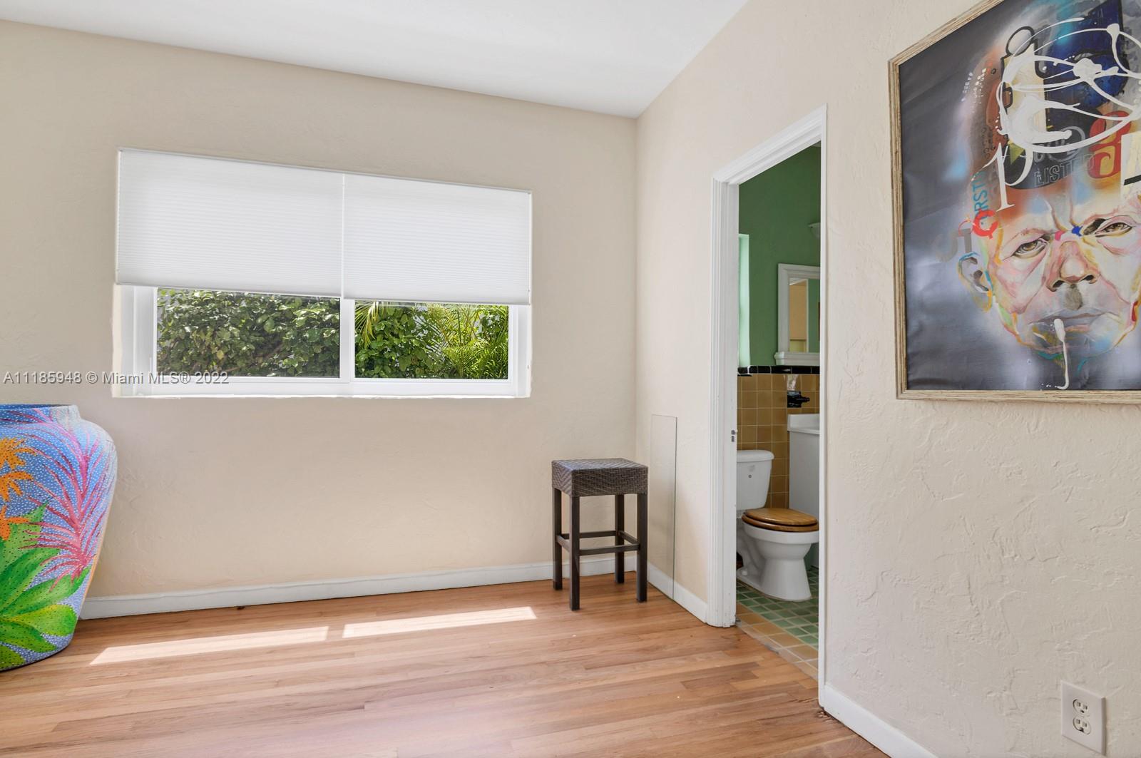 5429 Alton Road Miami Beach, FL 33140 - Photo 13 of 20 a view of an empty room with wooden floor and a window