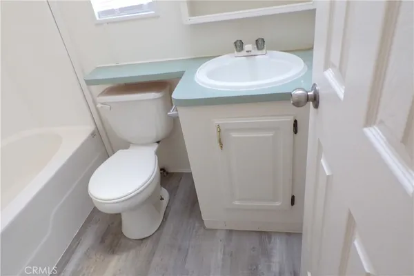 a white toilet sitting next to a white sink