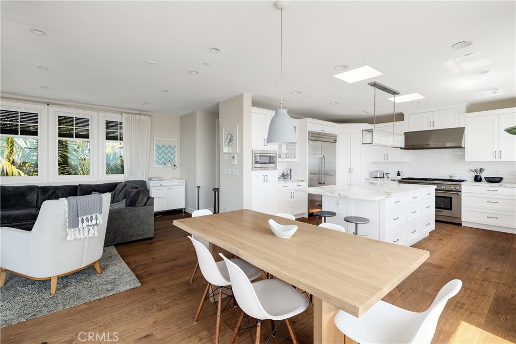 124 23rd Street Manhattan Beach, CA 90266 - Photo 30 of 50 a kitchen with stainless steel appliances kitchen island granite countertop a dining table chairs and a refrigerator